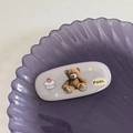 Vista macro dettagliata di una graziosa clip per capelli con orso su vassoio viola - Orso Grigio