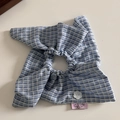 Dettaglio dell'elastico per capelli a quadretti blu con bottone a fiore e etichetta - Elastico per Capelli con Foulard a Quadri Blu