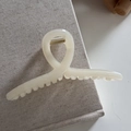 Minimalist cream resin shark hair claw clip detail on aesthetic textured book cover - Off-white