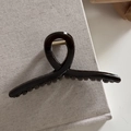 Detail showing high-gloss brown tortoiseshell hair claw clip with metallic spring mechanism - Transparent Black