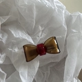Detailed close-up of handmade amber resin bow clip with France Handmade engraving - Coffee