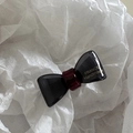 Detailed macro view of black and dark red bow hair clip with FRANCE Handmade gold text - Gray