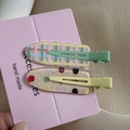 Detailed macro view of two fruit-style hair clips with glitter and checkered patterns - Pop Jelly Beans