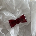 Detailed close-up of dark red handmade bow hair clip with gold France lettering - Red