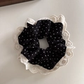 Detailansicht eines schwarzen Polka-Dot-Haargummis mit feiner weißer Spitzenstickerei - Schwarzer Polka Dot
