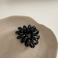 Élastique à cheveux spirale noir minimaliste sur un plateau décoratif en céramique beige - Noir