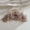 Dettaglio di un grande fermaglio per capelli in tulle rosa pieghettato su lino grezzo - Marrone
