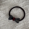 Detalle de lazo negro para el pelo con acento rojo y letras doradas de France Handmade - Gris