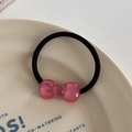Macro view of pink resin bow hair tie with translucent finish on ceramic plate - Hair Tie / Deep Pink
