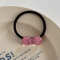 Close-up of a pink jelly resin bow on a high-elastic black hair tie over a cream plate - Hair Tie / Light Pink