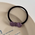 Close-up of a purple resin bow hair tie with marble texture on a ceramic plate - Hair Tie / Purple