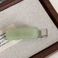 Detailed macro view of the matte light green rectangular acetate hair clip on a silver base - Green
