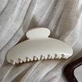 Detailed view of a cream-colored scalloped hair claw clip on soft textured fabric - Simple Fan-Shaped / Off-white