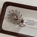 Macro view of dark grey spiral hair tie with a large champagne pearl on beige fabric - Telephone Line - Silver Ball / Silver