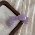 Gros plan d'une pince à cheveux nœud en acétate violet clair avec bords ondulés - Barrette / Violet