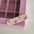 Detailaufnahme eines rosa Haarreifs mit Goldschleifen auf einer Samt-Schmuckschatulle - Rosa Haarspange mit Goldener Schleife