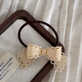 Vue détaillée d'une pince à cheveux papillon crème avec un élastique sur bois - Cravate à cheveux / Beige