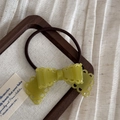 Détail d'une barrette à nœud papillon en acétate vert olive avec des bords ajourés - Cravate à cheveux / Vert