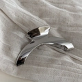 Nahaufnahme der geschwungenen silbernen Haarklammer aus Metall mit Hochglanz-Finish - Silber