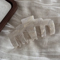 Detailed macro view of acetate hair claw showing marble texture and France Handmade logo - Beige