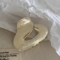Detailed close-up of a pearlescent cream heart hair claw clip with golden metal teeth - Clear White