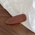 Detailed macro view of the brown acetate clip with gold France Handmade logo - Brown