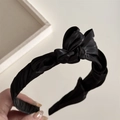 Dettaglio del cerchietto in raso nero a pieghe con texture elegante e lucentezza setosa - Nero