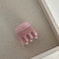 Detail of pink acetate hair claw with Barrette La France text on a beige tray - Pink