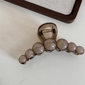 Detailed view of large marble bead hair claw clip in amber and cream resin with metal spring - Gray