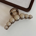 Detail of coffee brown resin hair claw clip with marble beads and gold spring - Creamy White