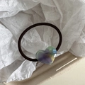 Makro-Detail eines elastischen Haargummis mit buntem Harzherz und France-Handmade-Aufdruck - AB-Farbe