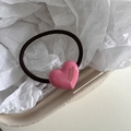 Detalle del dije de corazón rosa con logotipo hecho a mano en una goma elástica para pelo - Rosa
