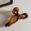 Détail d'une pince à cheveux nœud ambre avec texture résine mate et ressort en métal - Dégradé Café