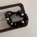 Dettaglio di elastico in organza nera con perle bianche sparse su tessuto di lino - Nero