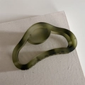 Olive green matte hollow hair claw clip with vintage dark speckle texture on beige canvas - Green Gradient