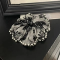 Dettaglio scrunchie in rete bianca con ricamo floreale nero e perle eleganti - Bordo di Perle Ricamato - Bianco
