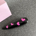 Close-up of black duckbill clip with bright magenta heart patterns on a grey surface - Teardrop / Black