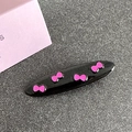 Close-up of black oval hair clip with cute pink bow patterns and glossy finish - Oval / Black