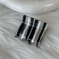 Détail d'une pince à cheveux carrée en acétate avec des rayures verticales bicolores - Rayé Noir Et Blanc Transparent