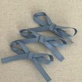 Detailansicht von drei eleganten staubblauen Schleifen-Haarclips mit Rippstruktur - Blau