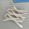 Detailaufnahme eines dreiteiligen Sets cremefarbener Stoff-Haarspangen mit Rippenstruktur - Beige