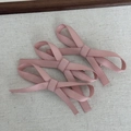 Detailansicht von drei rosa Haarklammern mit Stoffschleife auf minimalistischem Hintergrund - Rosa