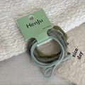 Detailed view of elastic hair bands in olive and mint green on branded card packaging - Green