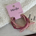 Detail showing elastic hair bands in pink and burgundy with woven texture on a card - Pink