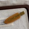 Classica clip per capelli a becco d'anatra marrone traslucido su sfondo di lino minimalista - Colore Gelatina Grande senza Traccia - Marrone