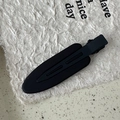 Macro view showing the matte black texture and smooth streamlined design of this hair clip - Black