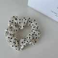 Gros plan détaillé du chouchou blanc crème à pois avec texture de tissu élégante et plis - Petits Pois Crème - Petite Taille