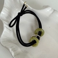 Détail d'un élastique à cheveux avec anneaux en jade vert et accent en métal argenté - Vert