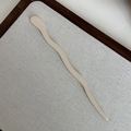 Nahaufnahme einer minimalistischen cremefarbenen Acetat-Haarnadel auf einem Stofftablett - Creme