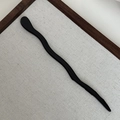 Detailaufnahme einer schwarzen wellenförmigen Haarnadel mit poliertem S-Kurven-Design - Schwarz